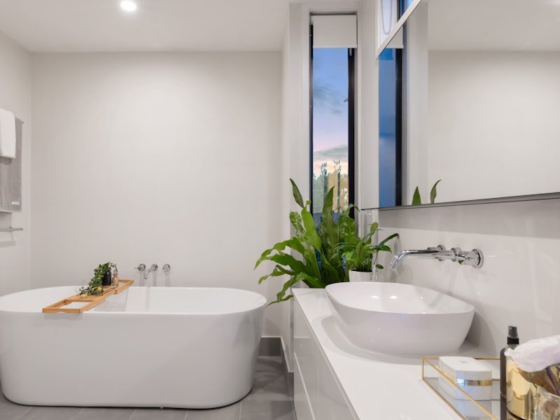 Warm contemporary bathroom renovation with a walk-in shower, freestanding tub and natural stone tile, completed by Oak & Stone Remodeling.